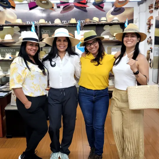 Four women in toquilla straw hats in a hat showroom